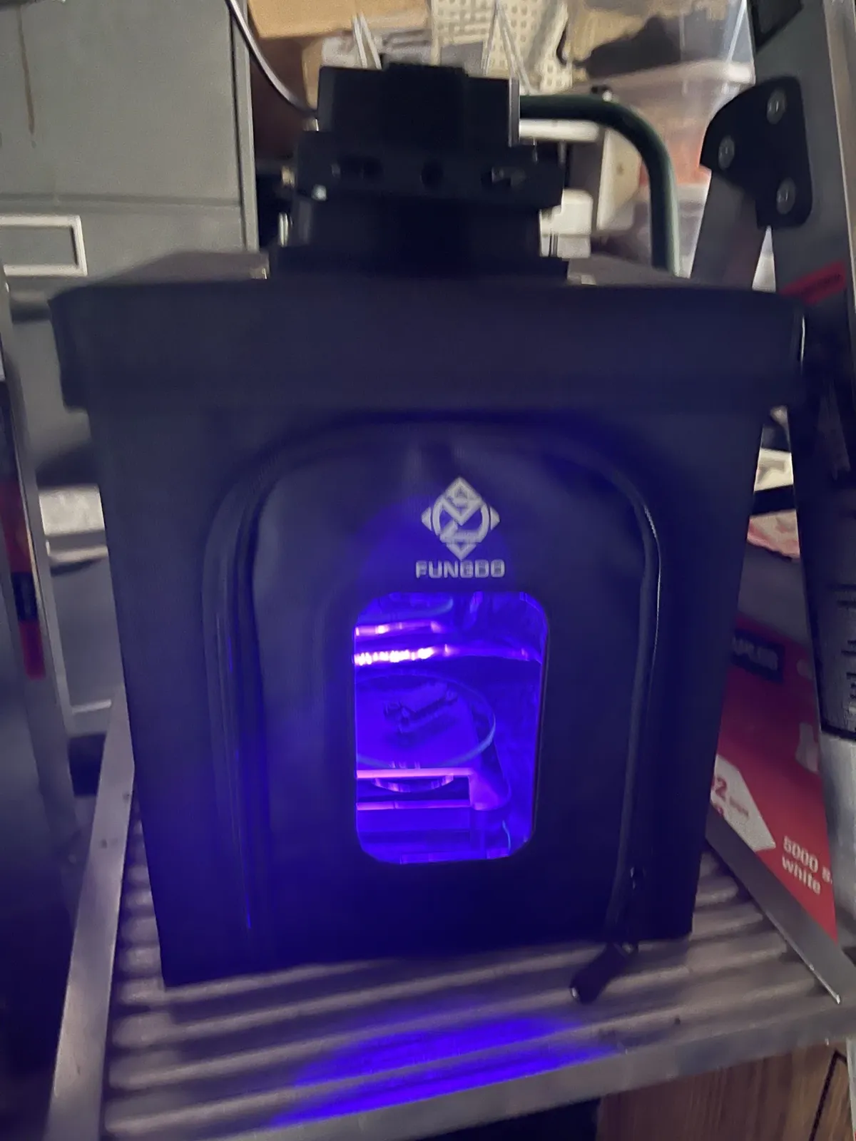 The Fungdo curing enclosure glowing purple through its window while a test piece cures inside.