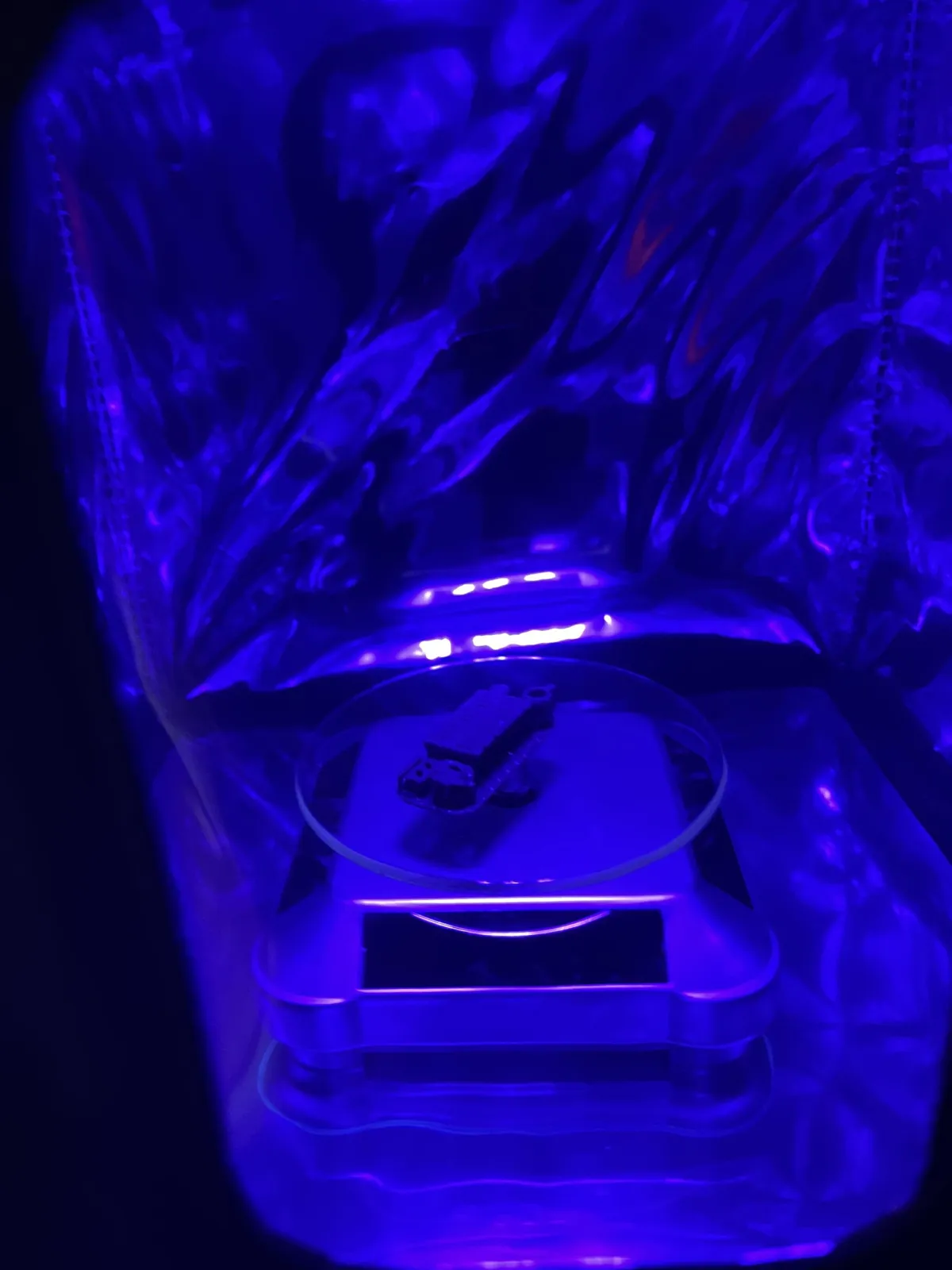Inside the enclosure: a test piece on the clear turntable under the UV light, with the reflective lining behind it.