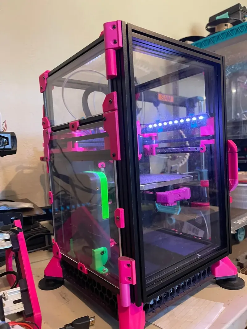 Pinkie's enclosed black Voron V0 with magenta printed parts, clear panels, and the illuminated interior visible.